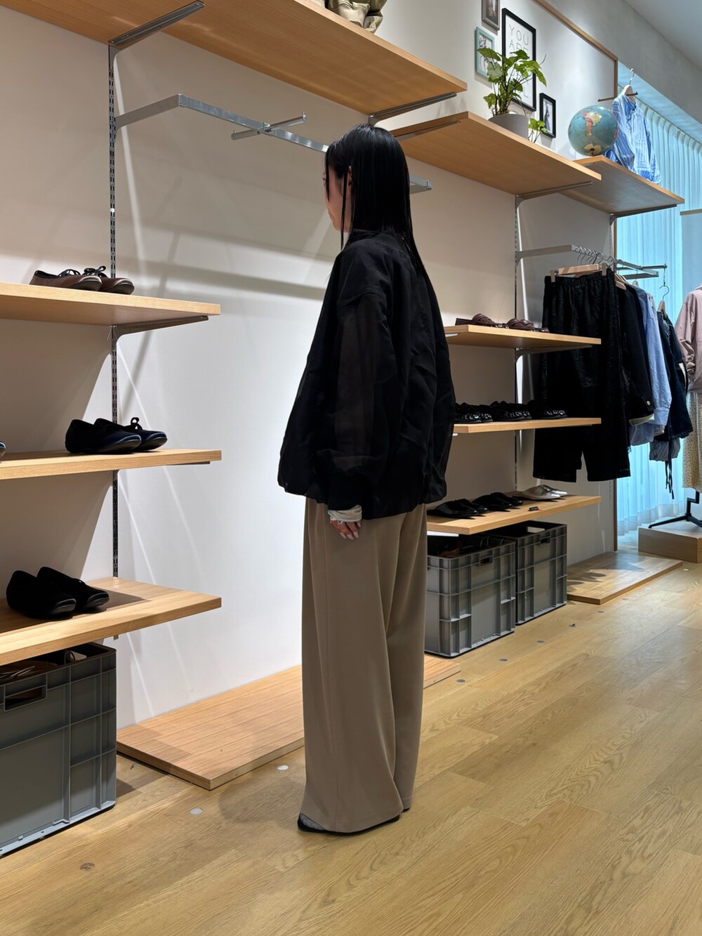 ブラック系のブルゾン、ベージュ系のカーディガン/ボレロ、ベージュ系のスラックスを着用したレディースの春コーディネートの3枚目の写真