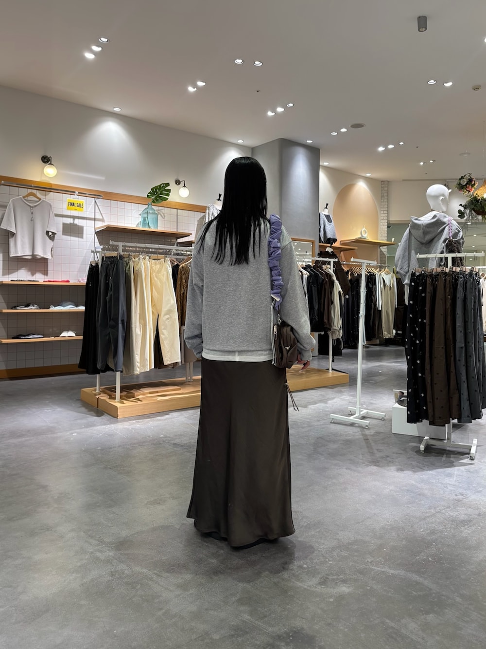 グレー系のスウェット、ホワイト系のTシャツ/カットソー、グレー系のスカートを着用したレディースの秋コーディネートの2枚目の写真