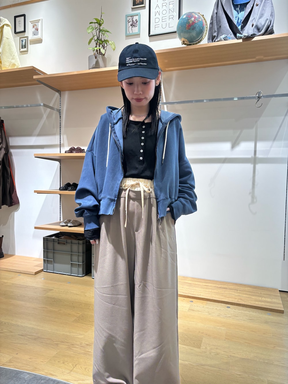 ブルー系のパーカー、ブラック系のTシャツ/カットソー、ベージュ系のスラックスを着用したレディースの春コーディネートの5枚目の写真