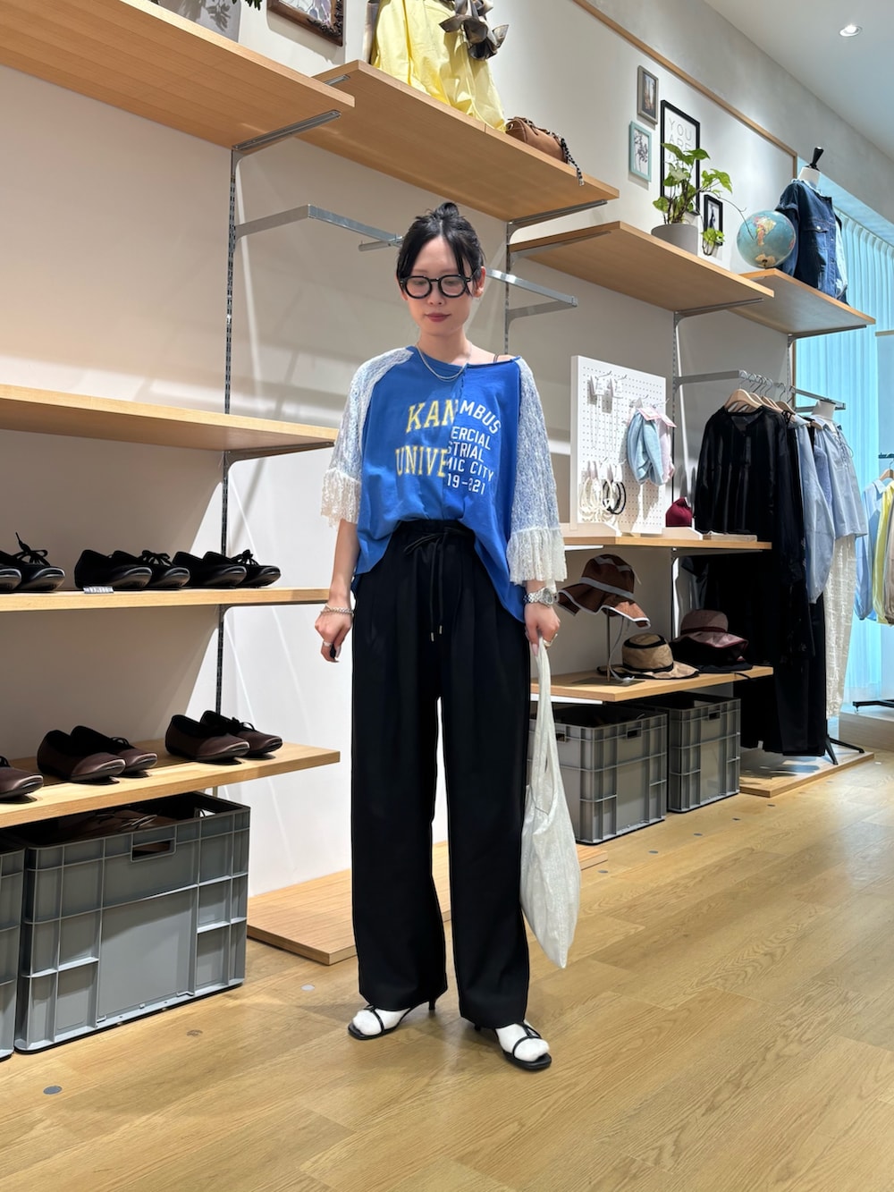 ブルー系のTシャツ/カットソー、ブラック系のその他パンツ、ホワイト系のトートバッグを着用したレディースの春コーディネートの2枚目の写真