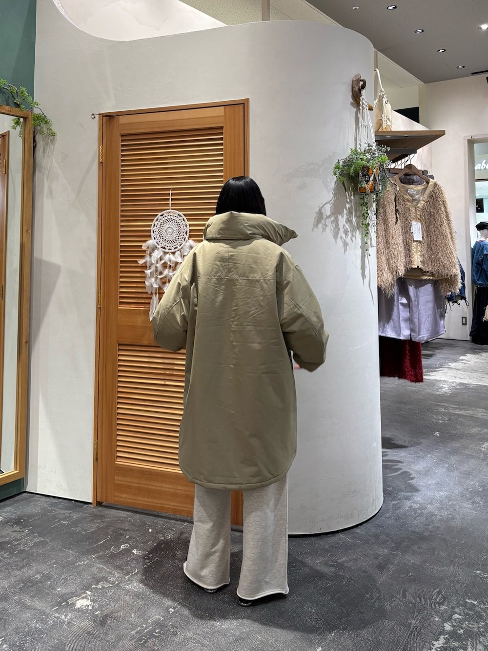 ベージュ系のダウンジャケット/コート、ブラウン系のニット/セーター、ホワイト系のスウェットパンツを着用したレディースの冬コーディネートの2枚目の写真