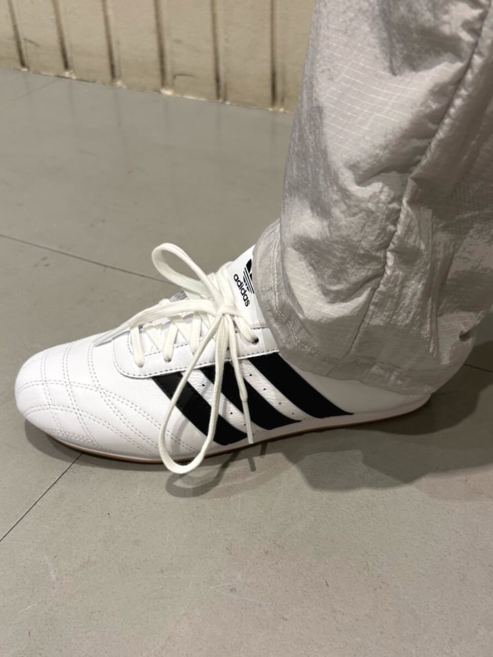 ブラック系のハンドバッグ、ホワイト系のスニーカー、ホワイト系のTシャツ/カットソーを着用したレディースの夏コーディネートの4枚目の写真