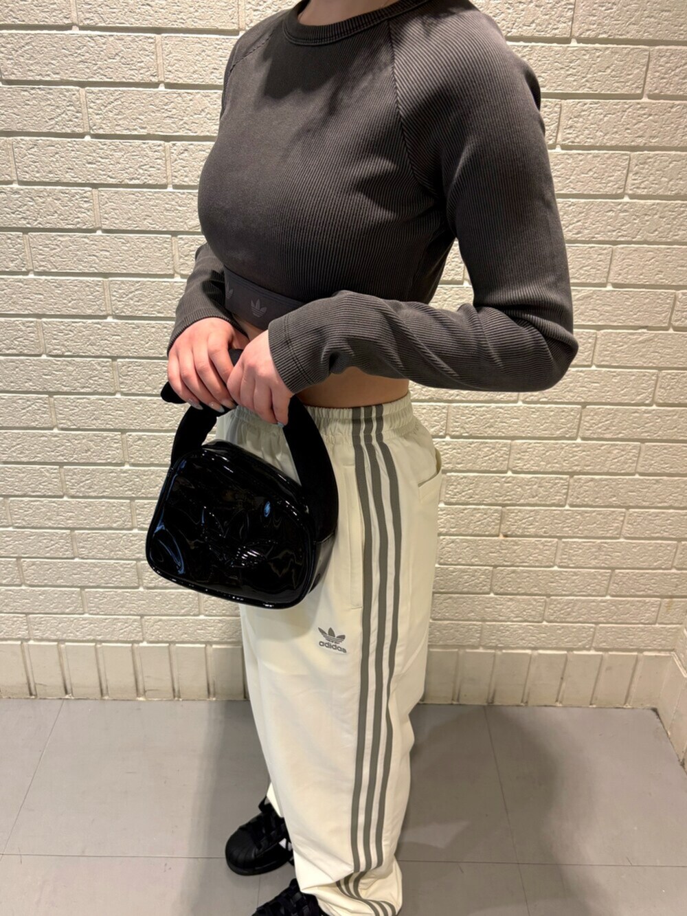 ブラック系のTシャツ/カットソー、ホワイト系のその他パンツ、ブラック系のスニーカーを着用したレディースの春コーディネートの3枚目の写真