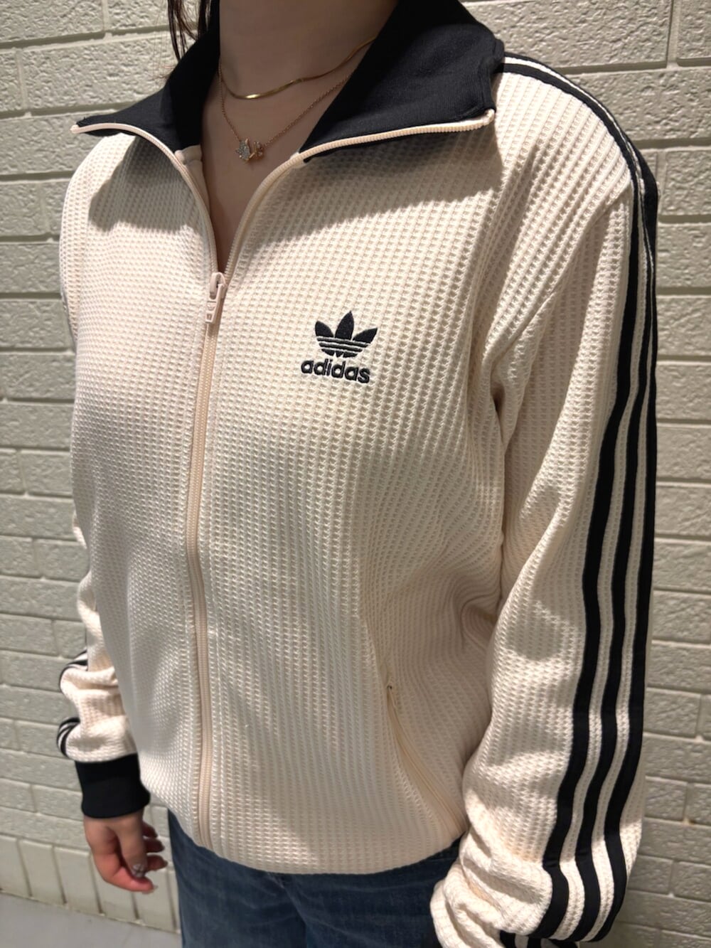 ホワイト系のジャージ、ブラウン系のスニーカーを着用したレディースの秋コーディネートの3枚目の写真