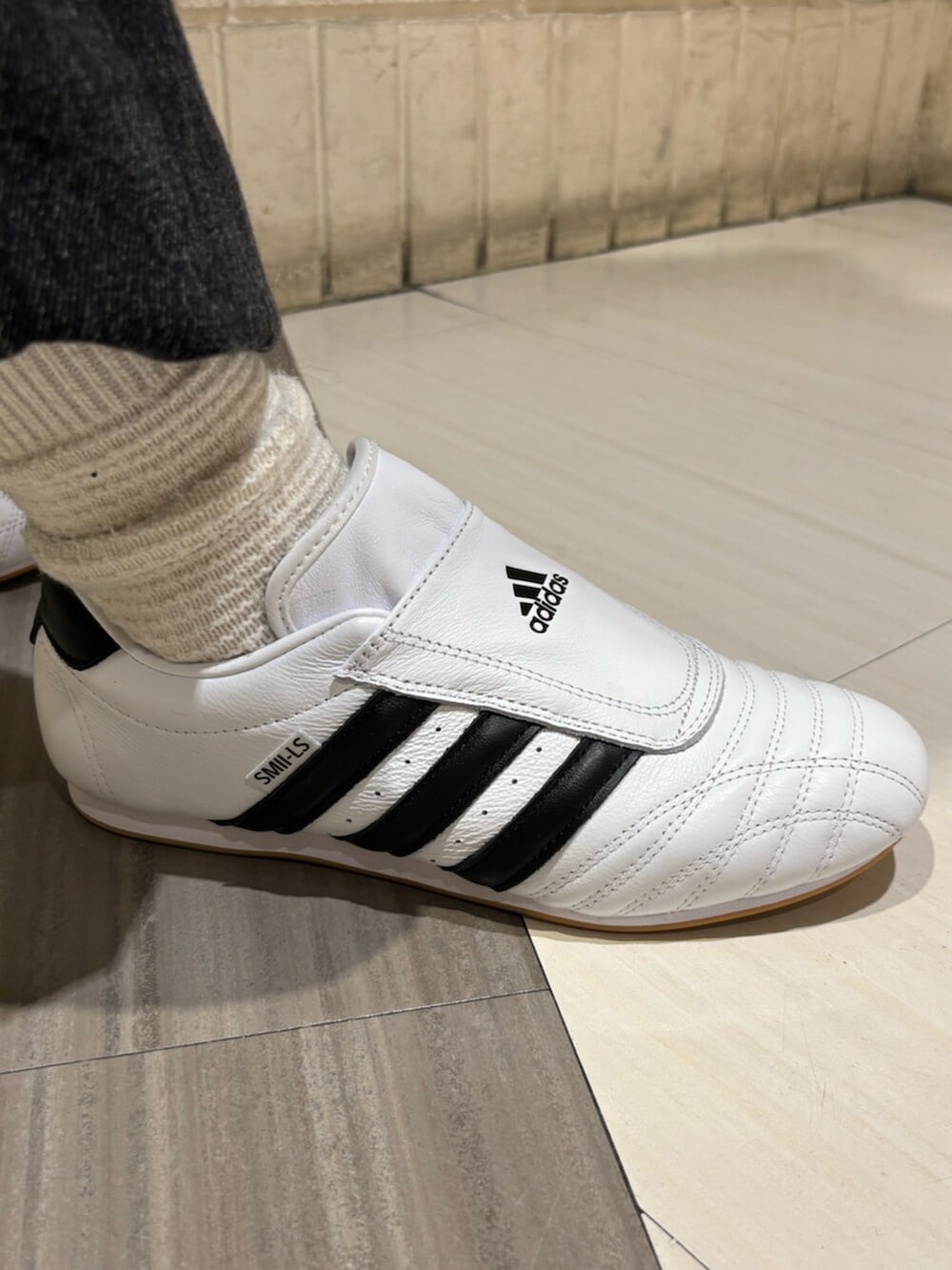 ブラック系のナイロンジャケット、ブラック系のデニムパンツ、シルバー系のショルダーバッグを着用したレディースの冬コーディネートの6枚目の写真