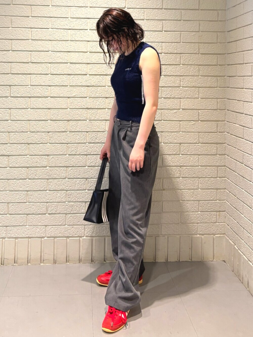 ブラック系のショルダーバッグ、レッド系のスニーカー、ブルー系のジャケット/アウターを着用したレディースの夏コーディネートの2枚目の写真