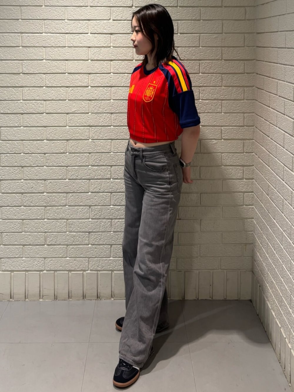 レッド系のTシャツ/カットソー、ブラック系のスニーカーを着用したレディースの秋コーディネートの2枚目の写真