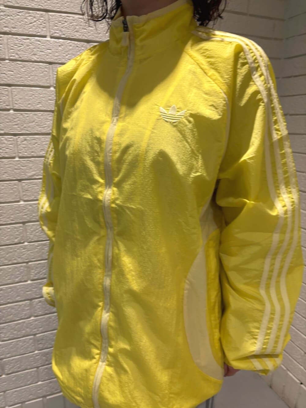 イエロー系のトップス、グレー系のスウェットパンツ、ブラック系のスニーカーを着用したレディースの春コーディネートの3枚目の写真