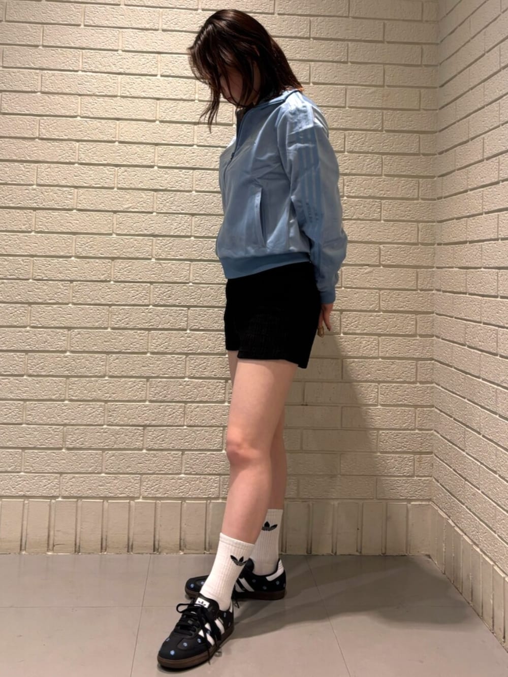 ブルー系のジャージ、ブラック系のスニーカーを着用したレディースの秋コーディネートの2枚目の写真