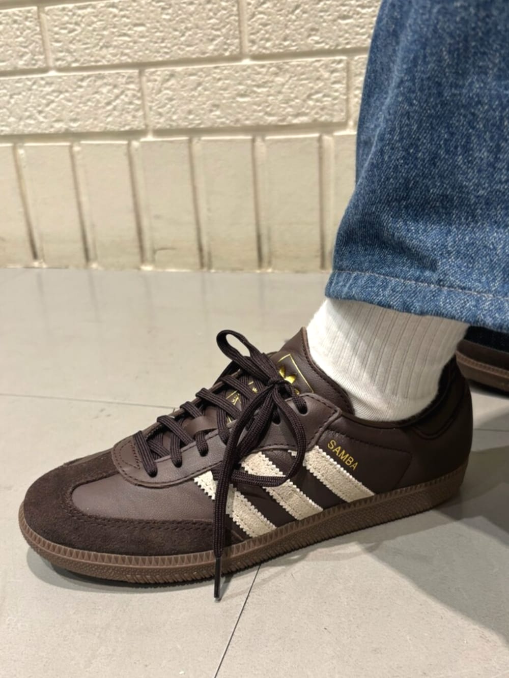 ホワイト系のジャージ、ブラウン系のスニーカーを着用したレディースの秋コーディネートの4枚目の写真