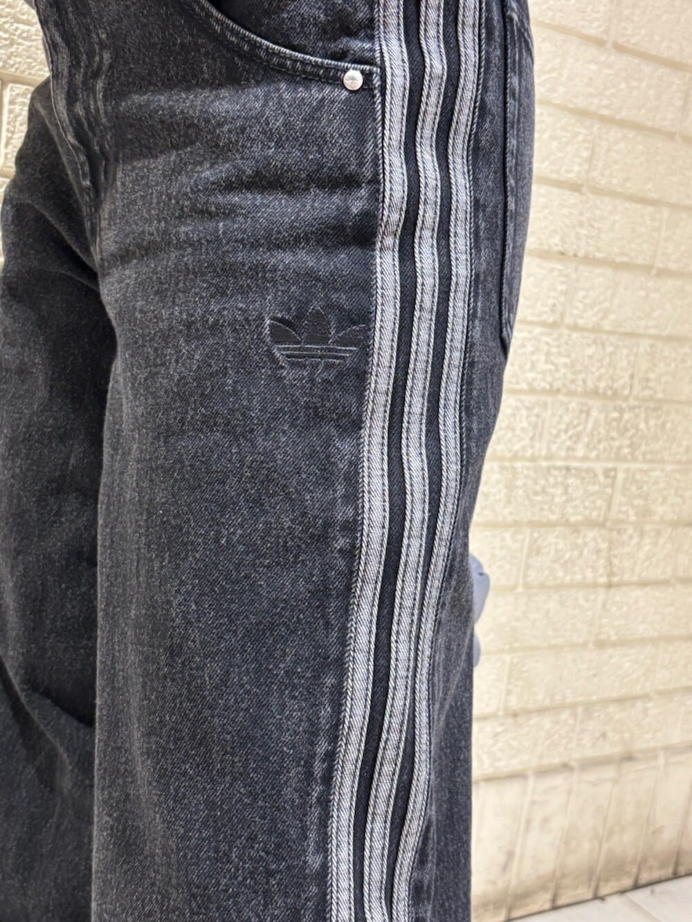 ブラック系のナイロンジャケット、ブラック系のデニムパンツ、シルバー系のショルダーバッグを着用したレディースの冬コーディネートの5枚目の写真