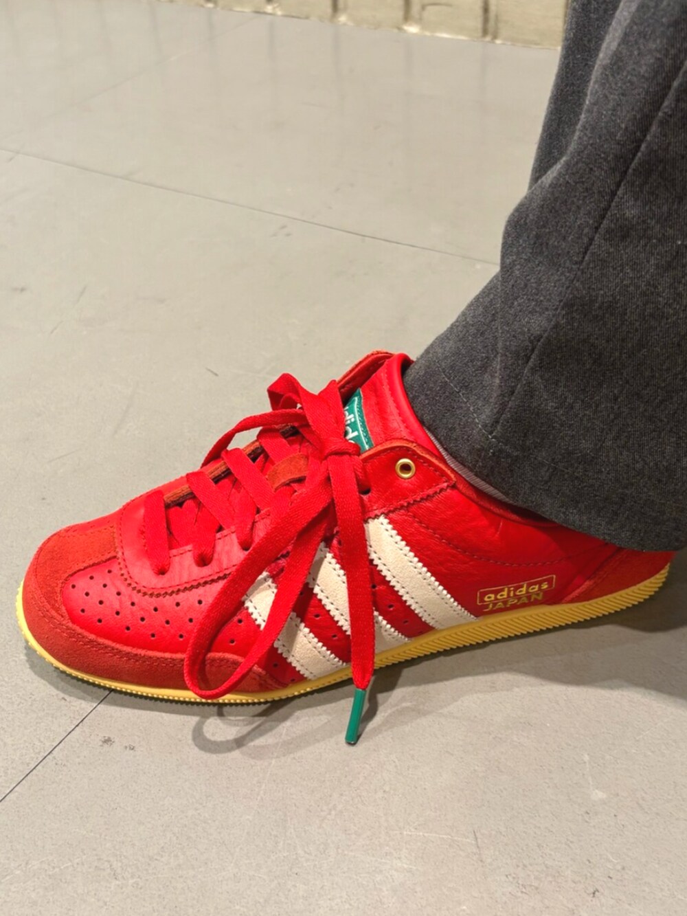 ブラック系のショルダーバッグ、レッド系のスニーカー、ブルー系のジャケット/アウターを着用したレディースの夏コーディネートの4枚目の写真