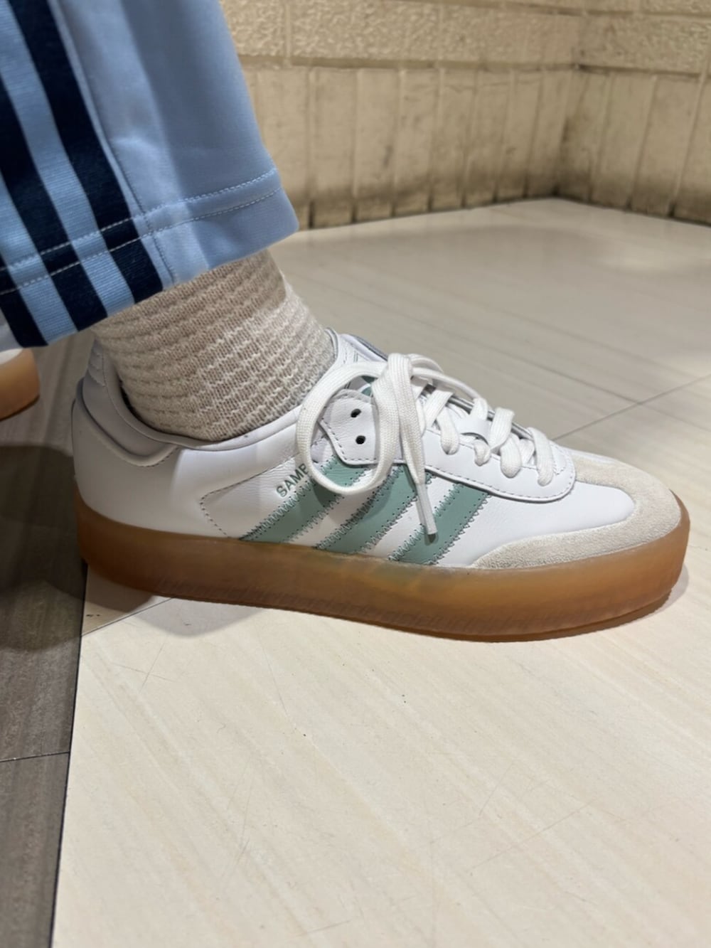 ホワイト系のTシャツ/カットソー、ブラック系のカーディガン/ボレロ、ブルー系のスウェットパンツを着用したレディースの冬コーディネートの4枚目の写真