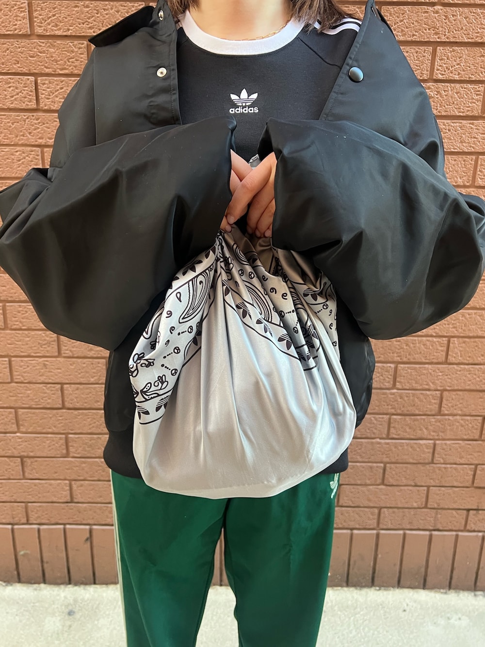 ベージュ系のスニーカー、ブラック系のTシャツ/カットソー、グリーン系のスウェットパンツを着用したレディースの冬コーディネートの5枚目の写真