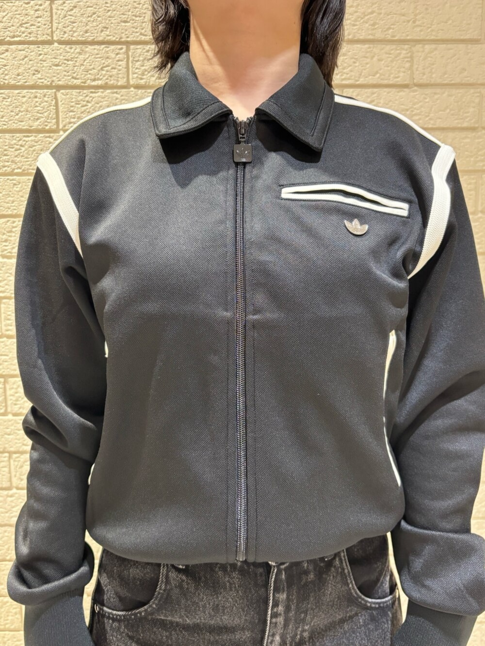 ブラック系のナイロンジャケット、ブラック系のデニムパンツ、シルバー系のショルダーバッグを着用したレディースの冬コーディネートの4枚目の写真