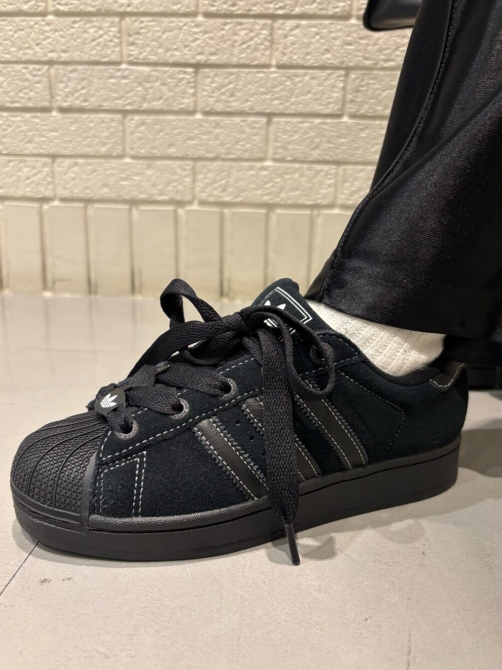 ブラック系のその他パンツ、ブラック系のスニーカー、ブラック系のショルダーバッグを着用したレディースの春コーディネートの4枚目の写真