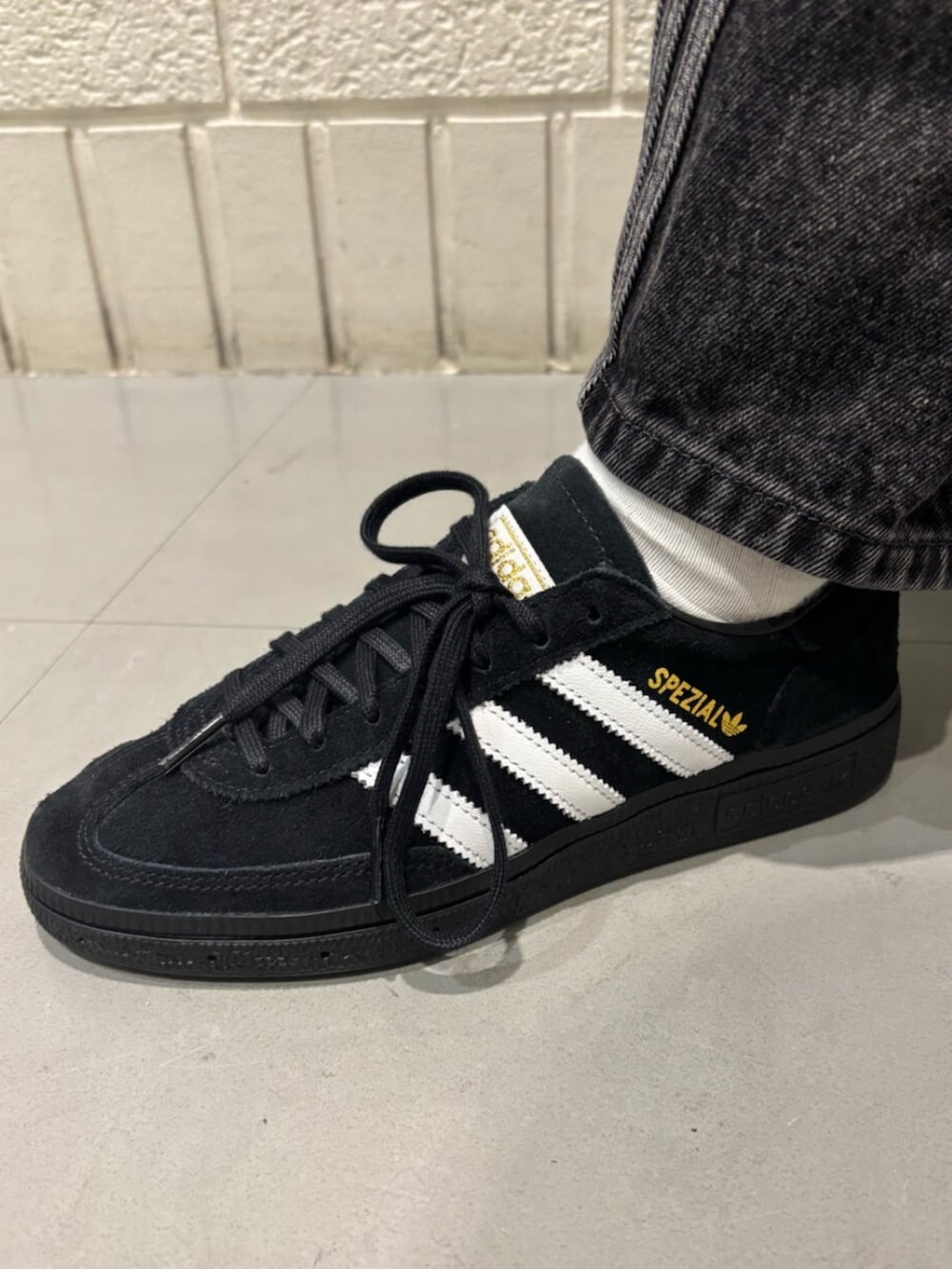 ブラウン系のナイロンジャケット、ブラック系のパンツ、ブラック系のスニーカーを着用したレディースの秋コーディネートの4枚目の写真