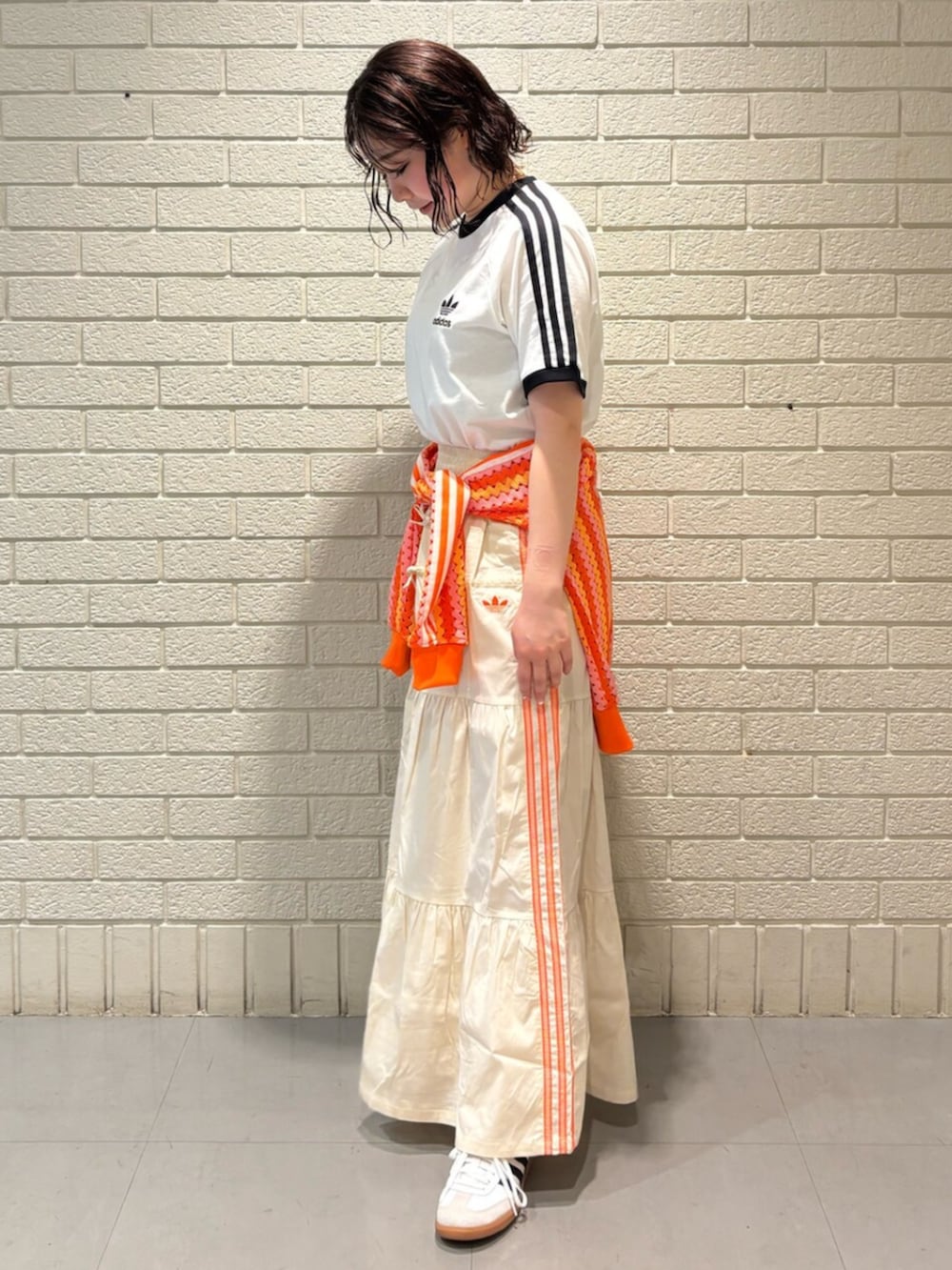 ホワイト系のTシャツ/カットソー、ホワイト系のスカート、ホワイト系のシューズを着用したレディースの春コーディネートの2枚目の写真