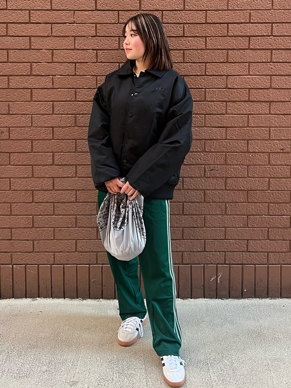 ベージュ系のスニーカー、ブラック系のTシャツ/カットソー、グリーン系のスウェットパンツを着用したレディースの冬コーディネートの3枚目の写真