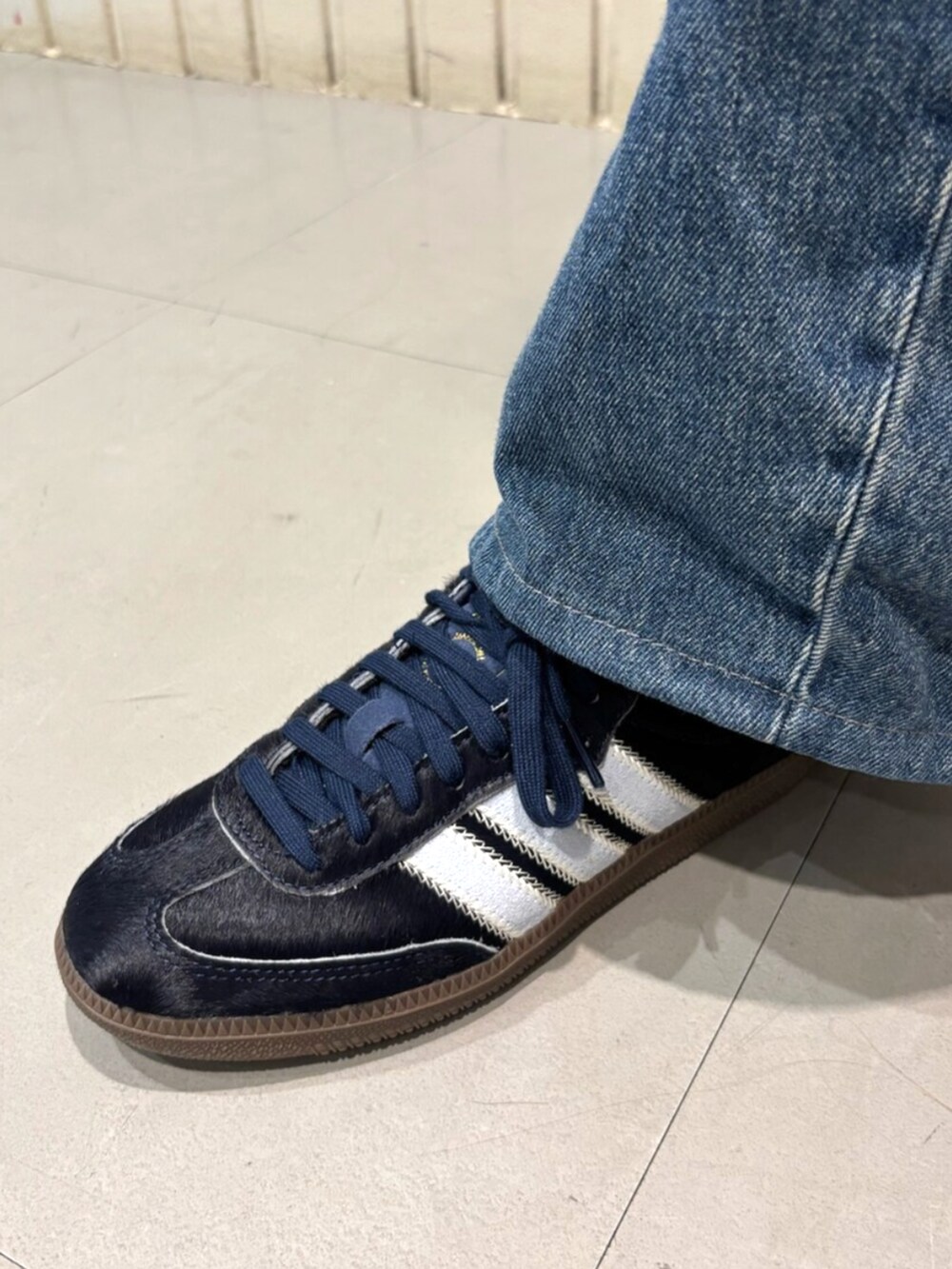 ホワイト系のトップス、ブルー系のスニーカーを着用したレディースの夏コーディネートの4枚目の写真