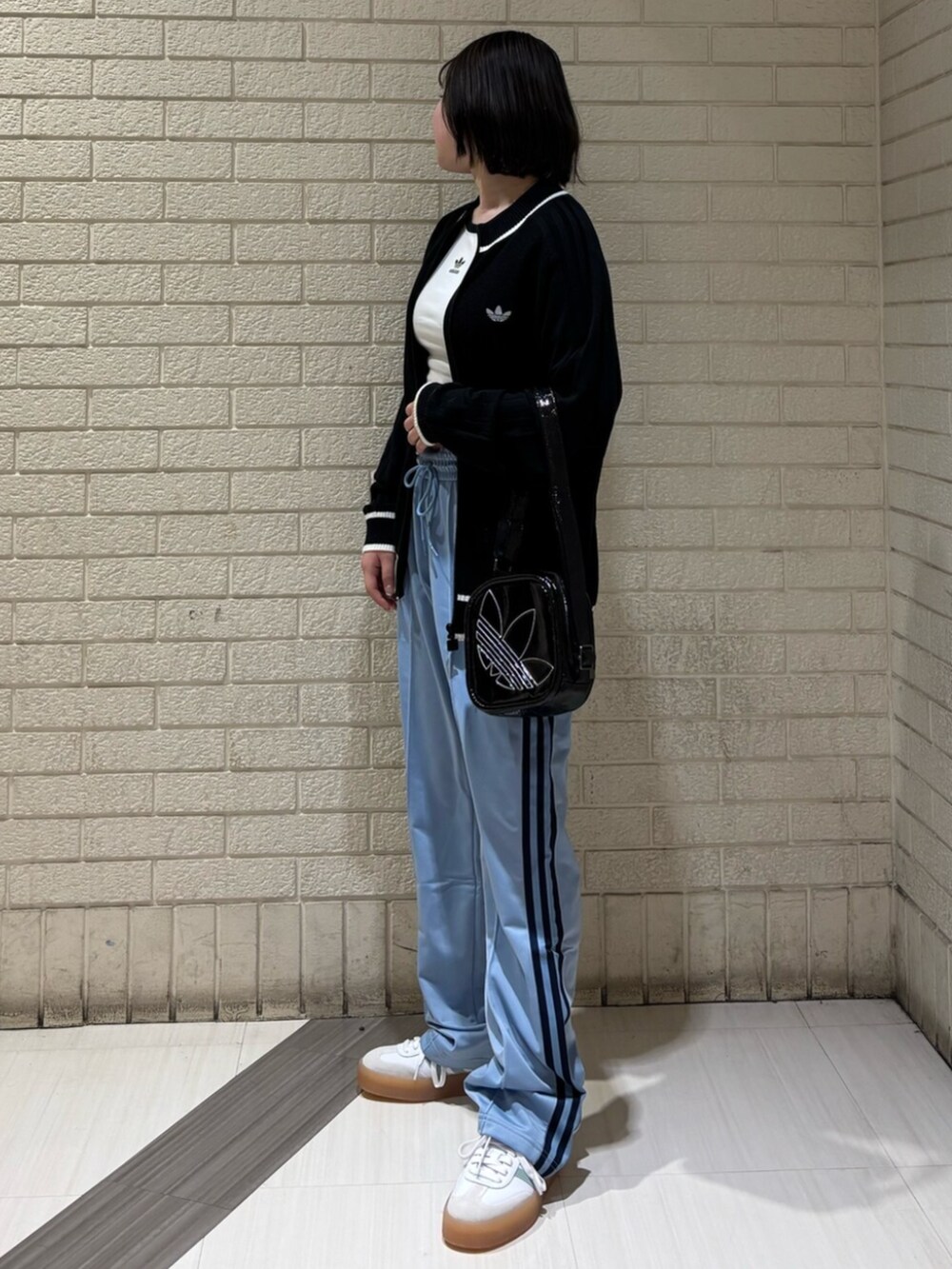 ホワイト系のTシャツ/カットソー、ブラック系のカーディガン/ボレロ、ブルー系のスウェットパンツを着用したレディースの冬コーディネートの2枚目の写真