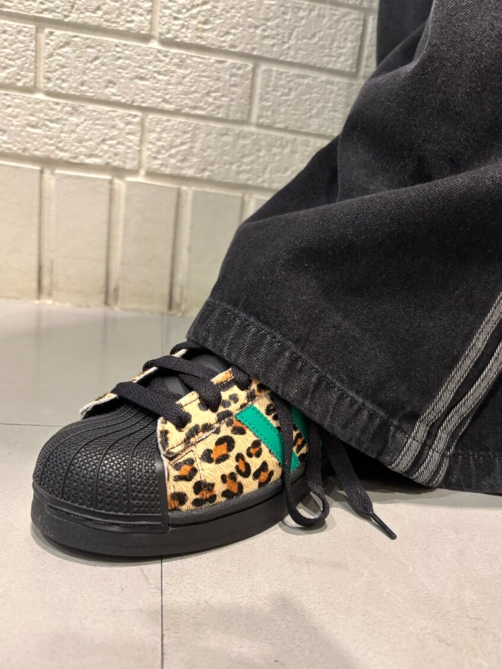 ブラック系のデニムパンツ、ブラック系のスニーカー、ブラック系のキャップを着用したレディースの夏コーディネートの4枚目の写真