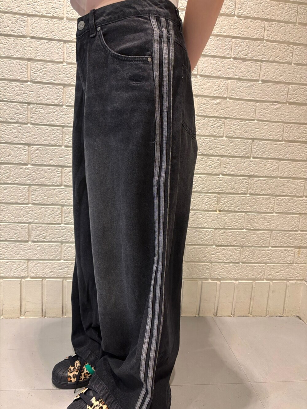 ブラック系のデニムパンツ、ブラック系のスニーカー、ブラック系のキャップを着用したレディースの夏コーディネートの3枚目の写真