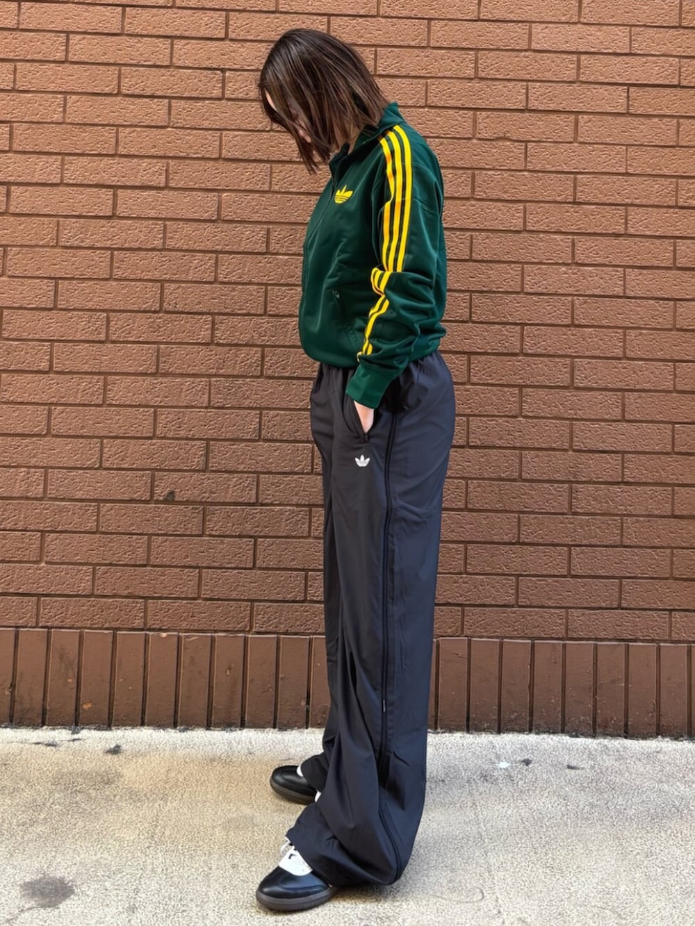 グリーン系のジャージ、ブラック系のその他パンツ、ブラック系のスニーカーを着用したレディースの春コーディネートの2枚目の写真