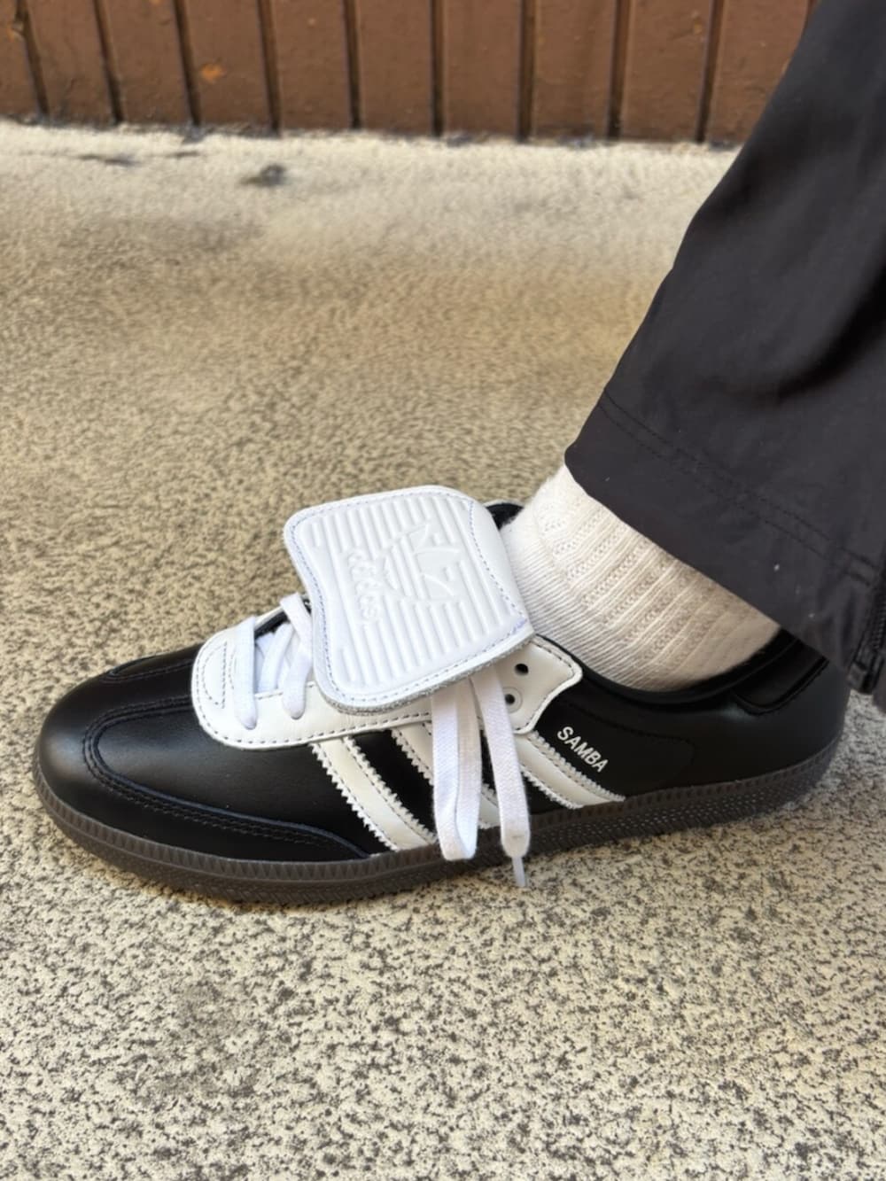 グリーン系のジャージ、ブラック系のその他パンツ、ブラック系のスニーカーを着用したレディースの春コーディネートの4枚目の写真