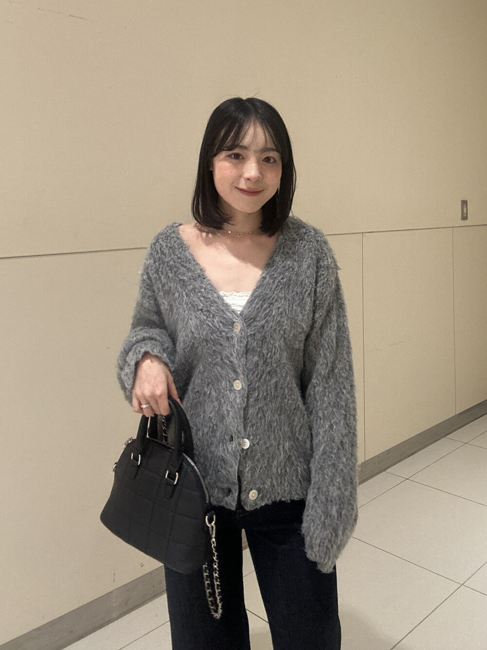 グレー系のニット/セーター、ブルー系のデニムパンツを着用したレディースの秋コーディネートの3枚目の写真