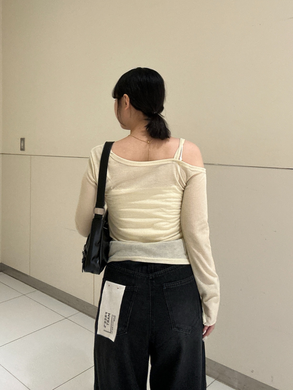 ベージュ系のTシャツ/カットソー、ブラック系のデニムパンツを着用したレディースの秋コーディネートの5枚目の写真