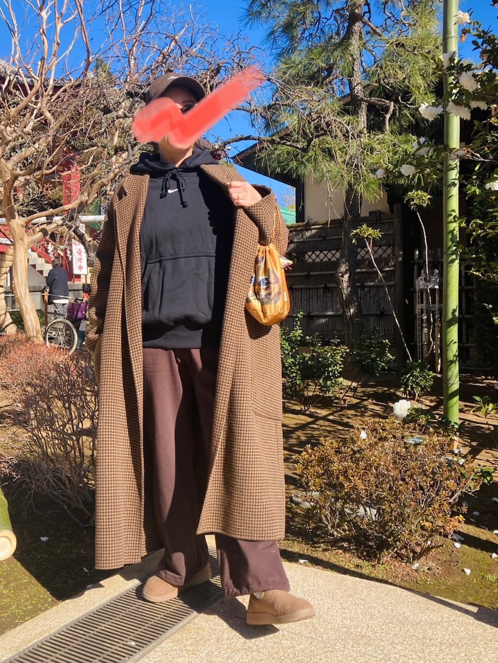 ブラウン系のスウェットパンツ、ブラック系のパーカー、ブラウン系のシューズを着用したレディースの冬コーディネートの2枚目の写真