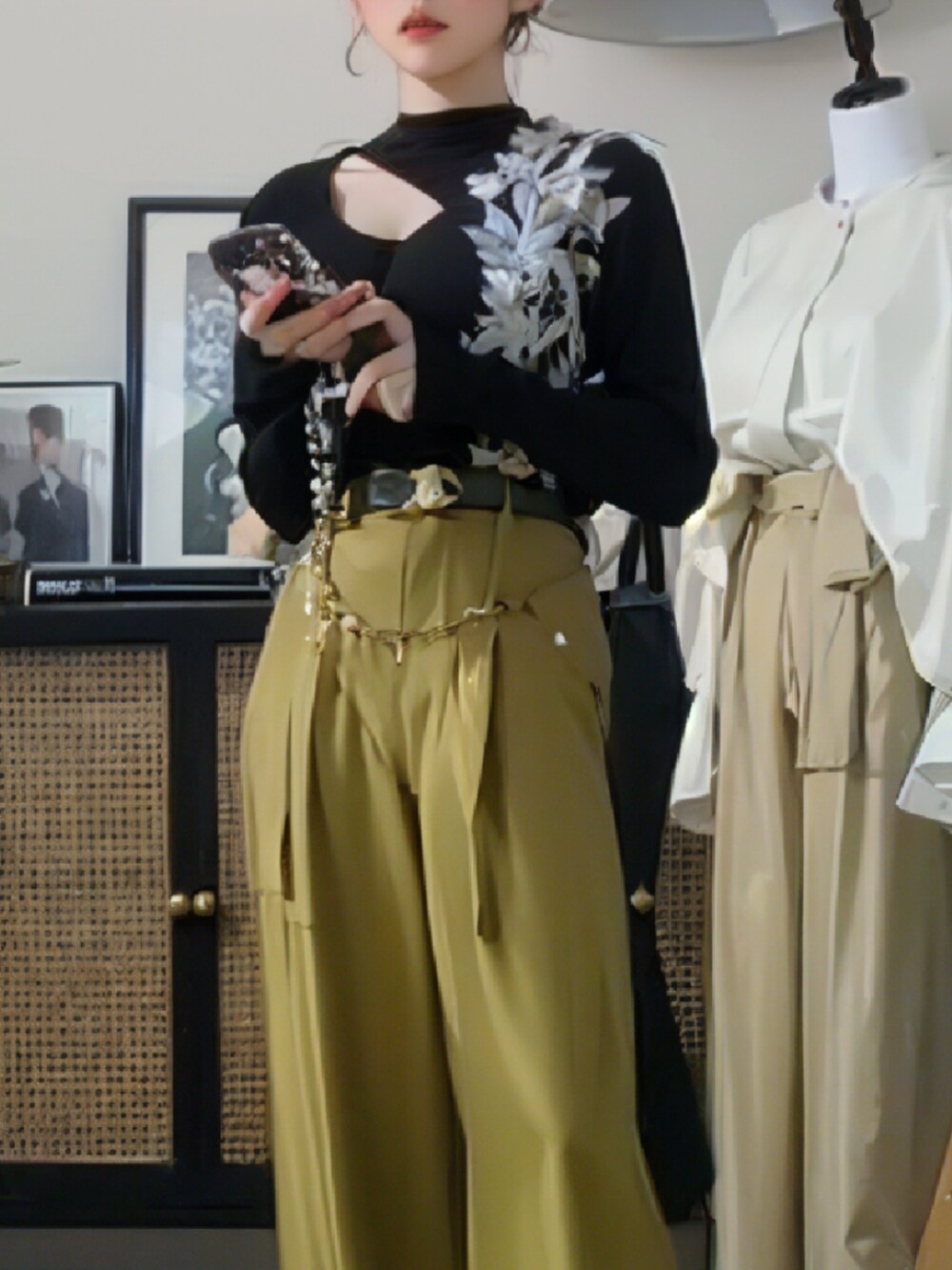 ブラウン系のチェスターコート、ブラック系のニット/セーター、グリーン系のスラックスを着用したレディースの秋コーディネートの2枚目の写真