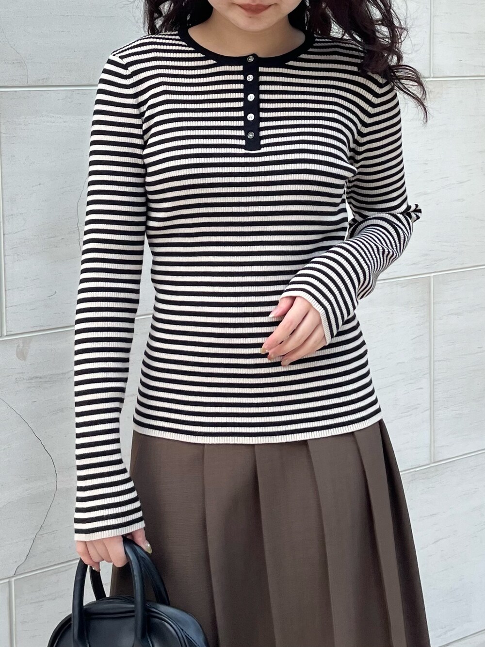 ブラック系のTシャツ/カットソー、ブラウン系のスカートを着用したレディースの秋コーディネートの3枚目の写真