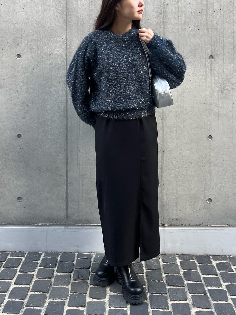 ブラック系のブーツ、シルバー系のショルダーバッグ、ブルー系のニット/セーターを着用したレディースの冬コーディネートの3枚目の写真