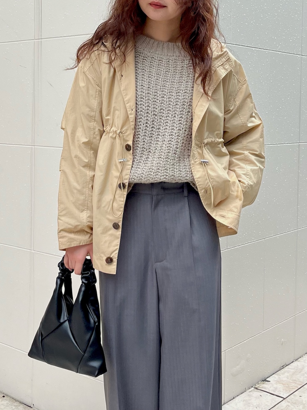 グレー系のスラックス、ベージュ系のその他アウターを着用したレディースの春コーディネートの2枚目の写真