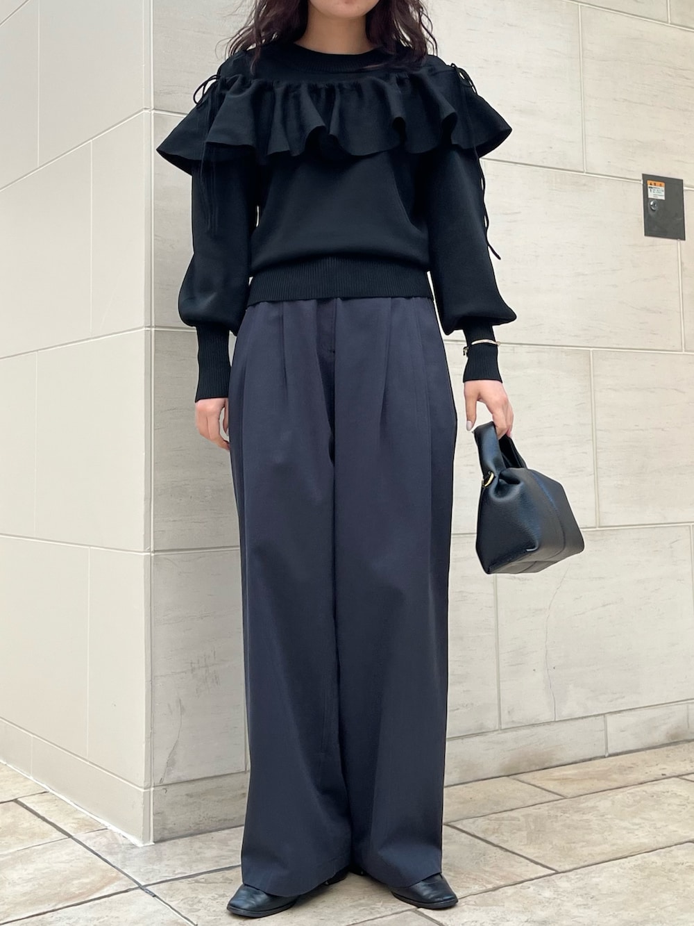 ブラック系のTシャツ/カットソー、ブラック系のハンドバッグを着用したレディースの冬コーディネートの2枚目の写真