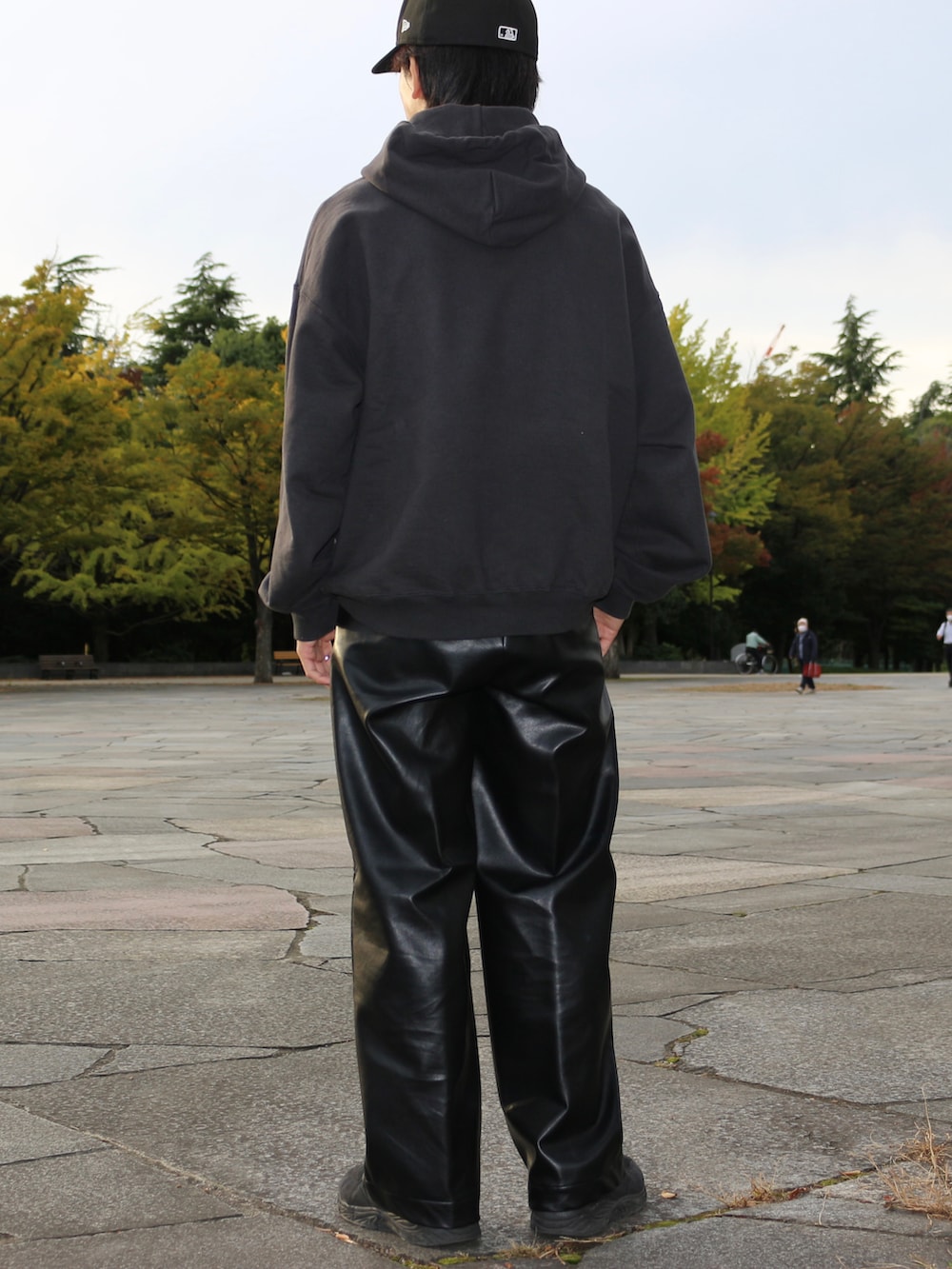 グレー系のパーカー、ブラック系のその他パンツ、ブラック系のスニーカーを着用したメンズの冬コーディネートの4枚目の写真