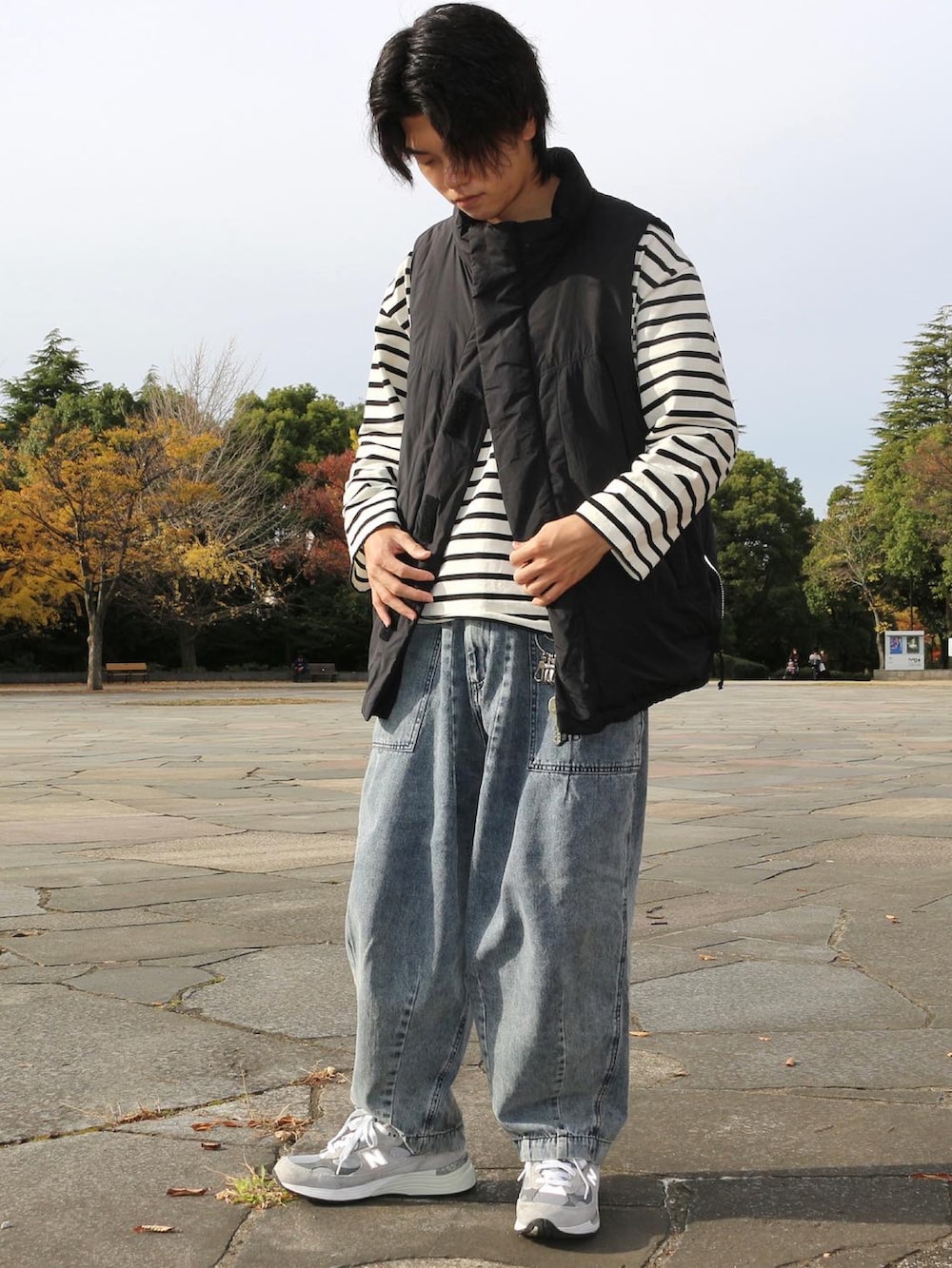 ブルー系のデニムパンツ、ブラック系のダウンベスト、ホワイト系のTシャツ/カットソーを着用したメンズの秋コーディネートの2枚目の写真