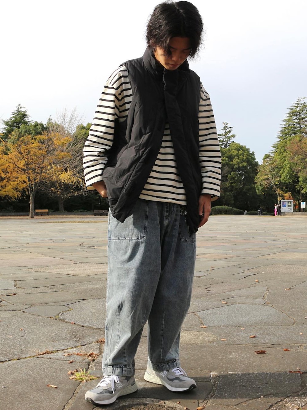 ブルー系のデニムパンツ、ブラック系のダウンベスト、ホワイト系のTシャツ/カットソーを着用したメンズの秋コーディネートの3枚目の写真