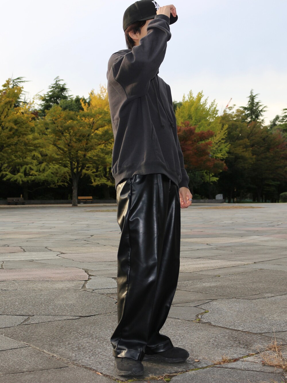 グレー系のパーカー、ブラック系のその他パンツ、ブラック系のスニーカーを着用したメンズの冬コーディネートの2枚目の写真