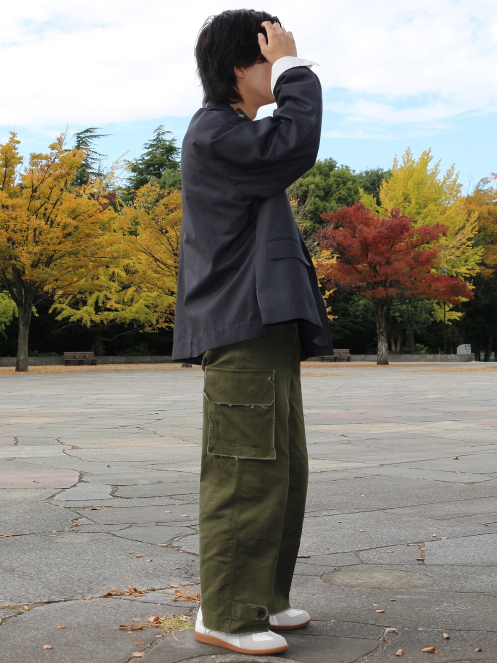 グレー系のテーラードジャケット、グリーン系のカーゴパンツ、ホワイト系のスニーカーを着用したメンズの秋コーディネートの3枚目の写真