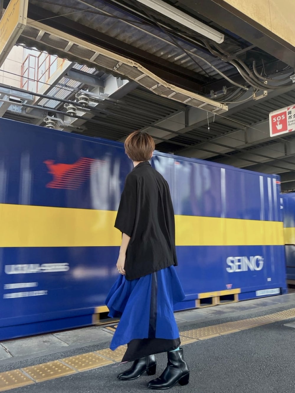 ブラック系のシャツ/ブラウス、ブルー系のスカート、ブラック系のブーツを着用したメンズの夏コーディネートの3枚目の写真