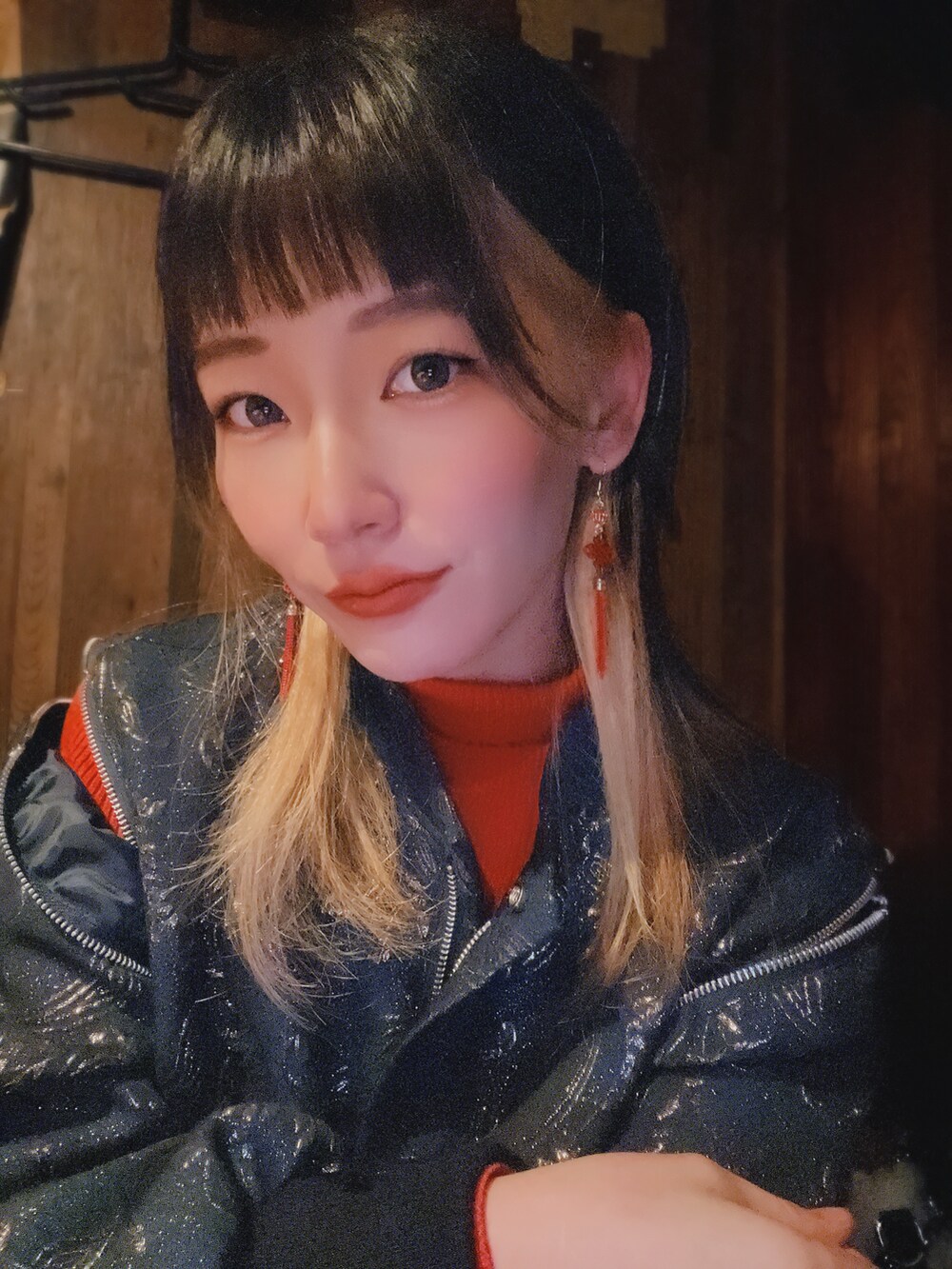 ホワイト系のショルダーバッグ、ブラック系のスタジャン、レッド系のニット/セーターを着用したレディースの冬コーディネートの2枚目の写真