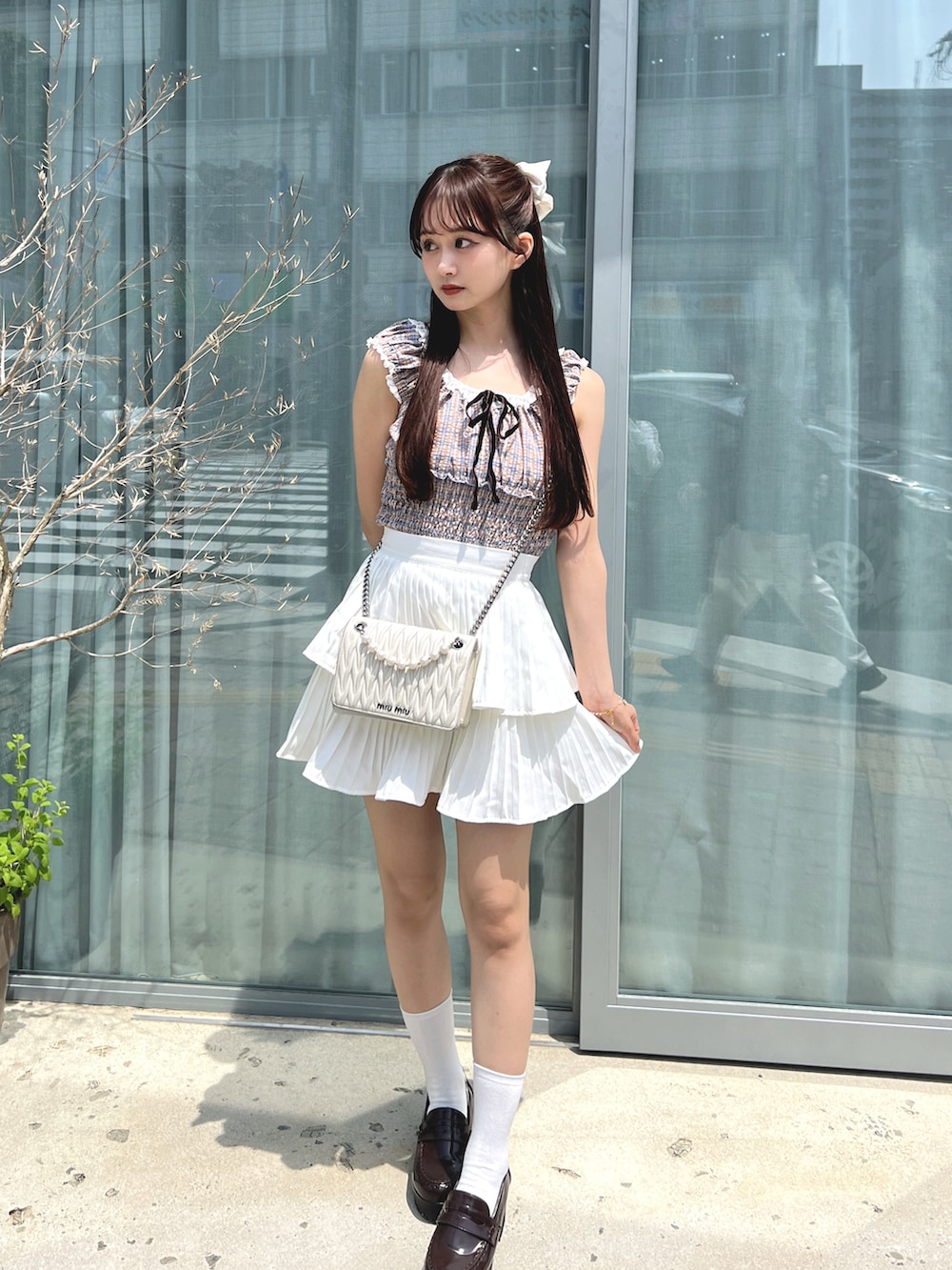 ピンク系のトップス、ホワイト系のスカートを着用したレディースの夏コーディネートの2枚目の写真