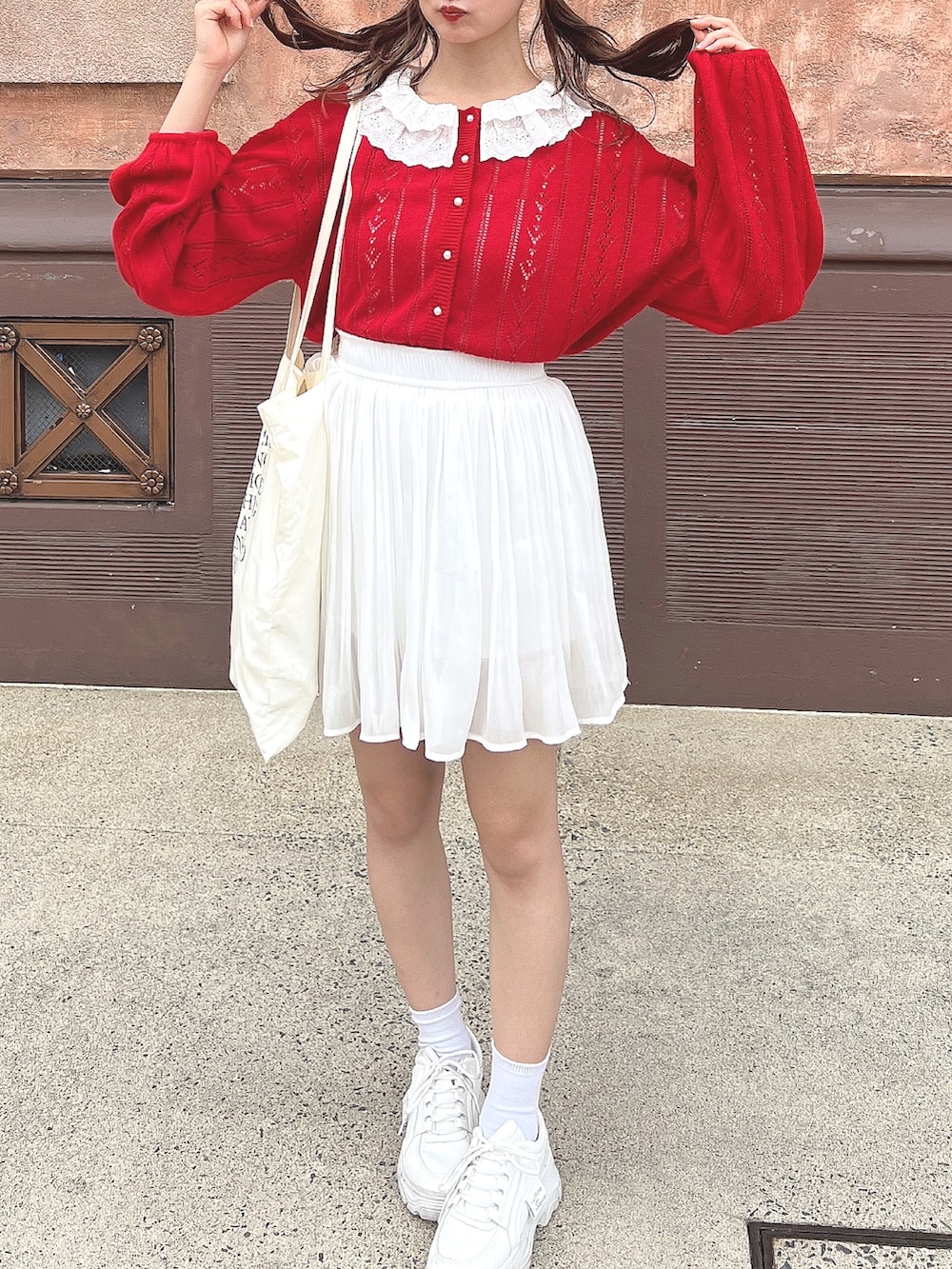 ブラック系のスカート、ホワイト系のスカート、レッド系のカーディガン/ボレロを着用したレディースの春コーディネートの3枚目の写真