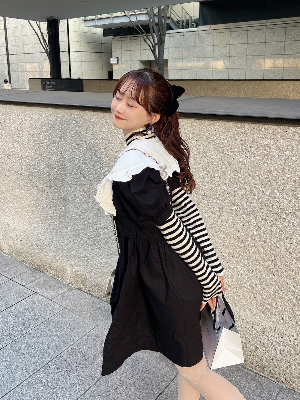 ブラック系のワンピースを着用したレディースの秋コーディネートの2枚目の写真