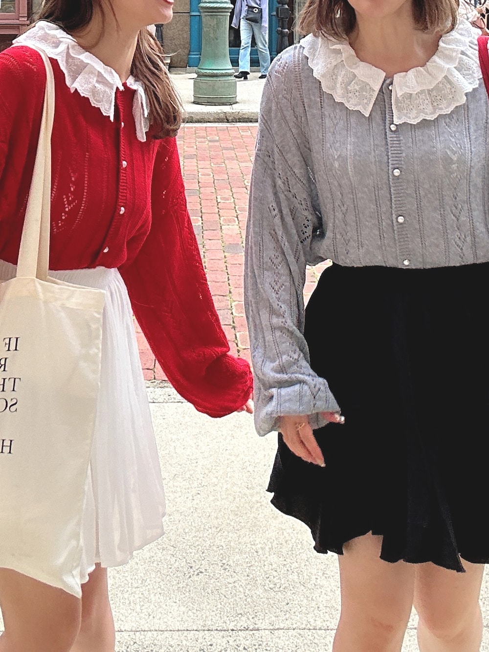 ブラック系のスカート、ホワイト系のスカート、レッド系のカーディガン/ボレロを着用したレディースの春コーディネートの2枚目の写真