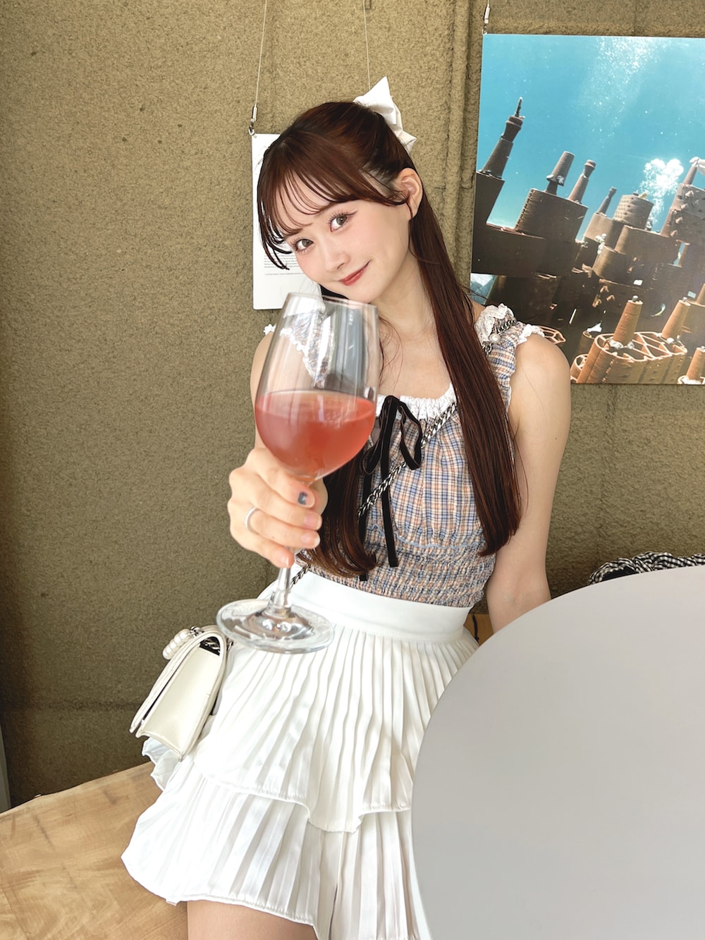 ピンク系のトップス、ホワイト系のスカートを着用したレディースの夏コーディネートの3枚目の写真