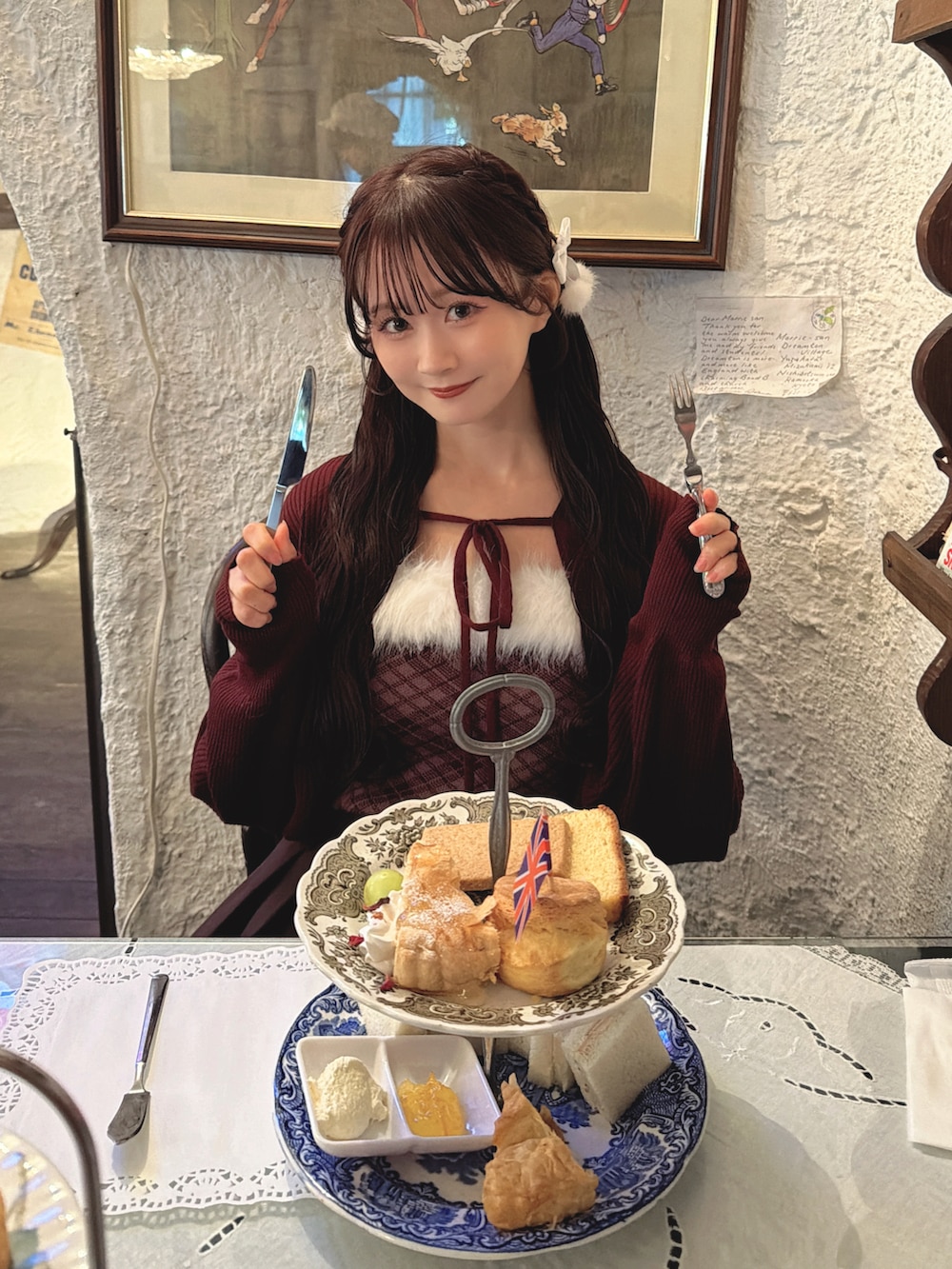 レッド系のカーディガン/ボレロ、ブラウン系のスカートを着用したレディースの秋コーディネートの3枚目の写真